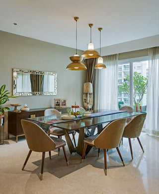 Dining room with a long table and chairs, featuring modern decor and large windows.