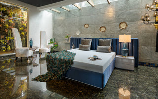 Modern bedroom with blue bed, big accent chairs.