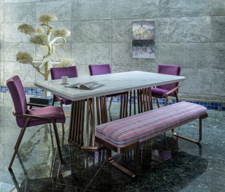 Marble top with sculpted metal base dining table accompanied with the luxurious dining chairs and a bench.