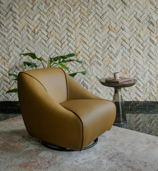 Brown armchair in a room with a textured wall and small table.