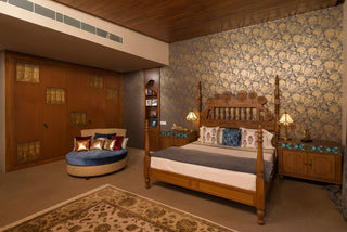 Bedroom with wooden bed, floral wallpaper, and decorative elements.