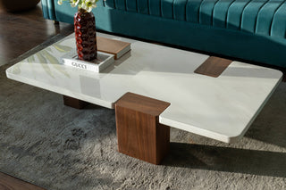 Teal sofa with decorative pillows and a coffee table in a living room setting.