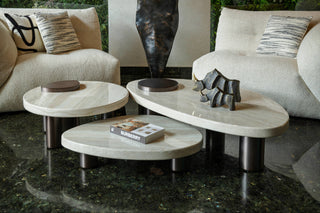 Modern living room with marble coffee tables and a sculpture.