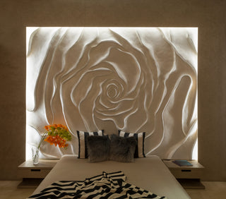 Decorative wall art of a rose in a bedroom setting with pillows and flowers.