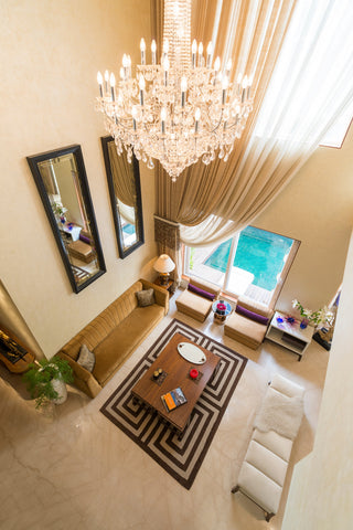 Luxurious living room with a chandelier, sofa, coffee table, and large window.
