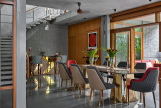 Modern Glass dining table area with multi fabric chairs, with bar table.