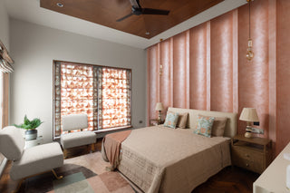 Modern bedroom with pink walls, a bed, and decorative elements.