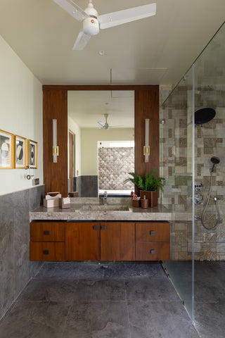 Modern bathroom with wooden vanity, mirror, and shower area.
