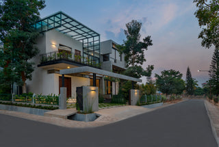Modern house with glass facade and greenery at dusk