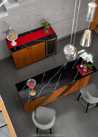 Modern interior design with a black and red counter, chairs, and pendant lights.