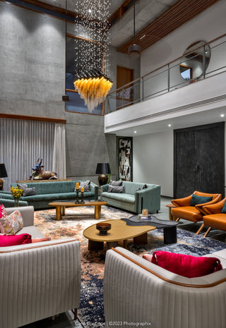 Modern living room with Fabric sofas, Leather chairs,a chandelier,and two center tables.
