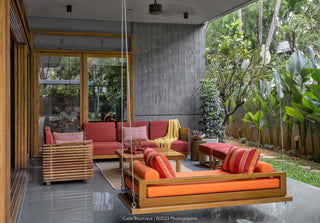 Modern outdoor seating area with colorful wooden furniture in a garden setting.