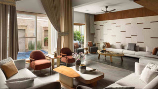 Modern living room with beige curtains, white walls, and a pool view.