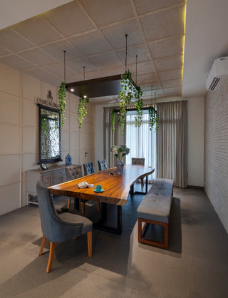Modern dining room with wooden table, chairs, and metal legs, and a large mirror on the wall.