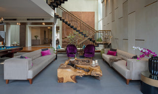 Modern living room with gray sofas, purple chairs, and a wooden coffee table.