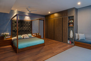 Modern bedroom with wooden bed, wardrobe, and seating area.