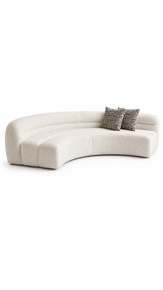 Curved beige sofa with patterned cushions on a white background