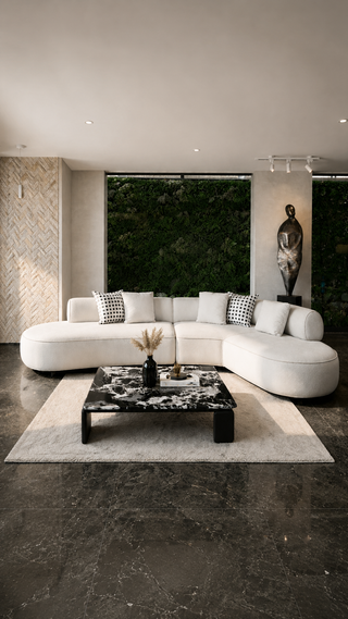 Modern living room with a white sectional sofa, black marble coffee table, and decorative elements.