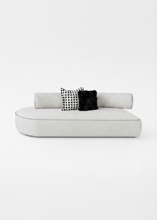 White sofa with black and white patterned cushions on a white background
